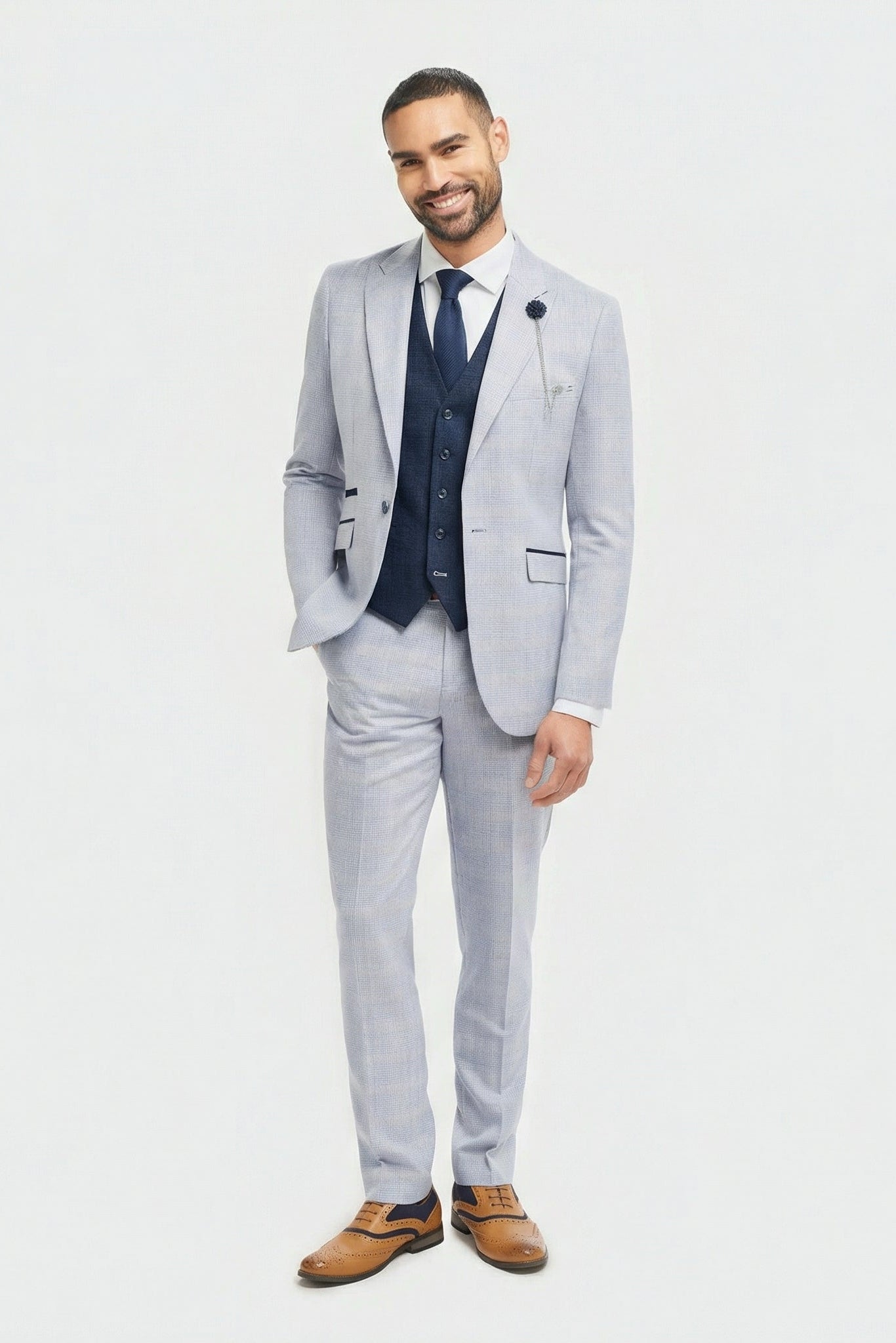 Man wearing a light gray suit with a vest on a white background