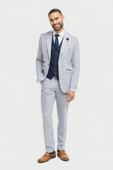 Man wearing a light gray suit with a vest on a white background